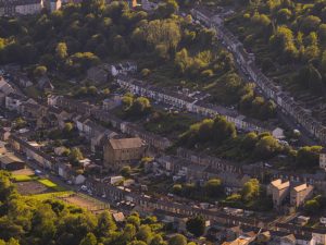An aerial view of a Welsh community, with rows of terraced houses stretching across a hillside.