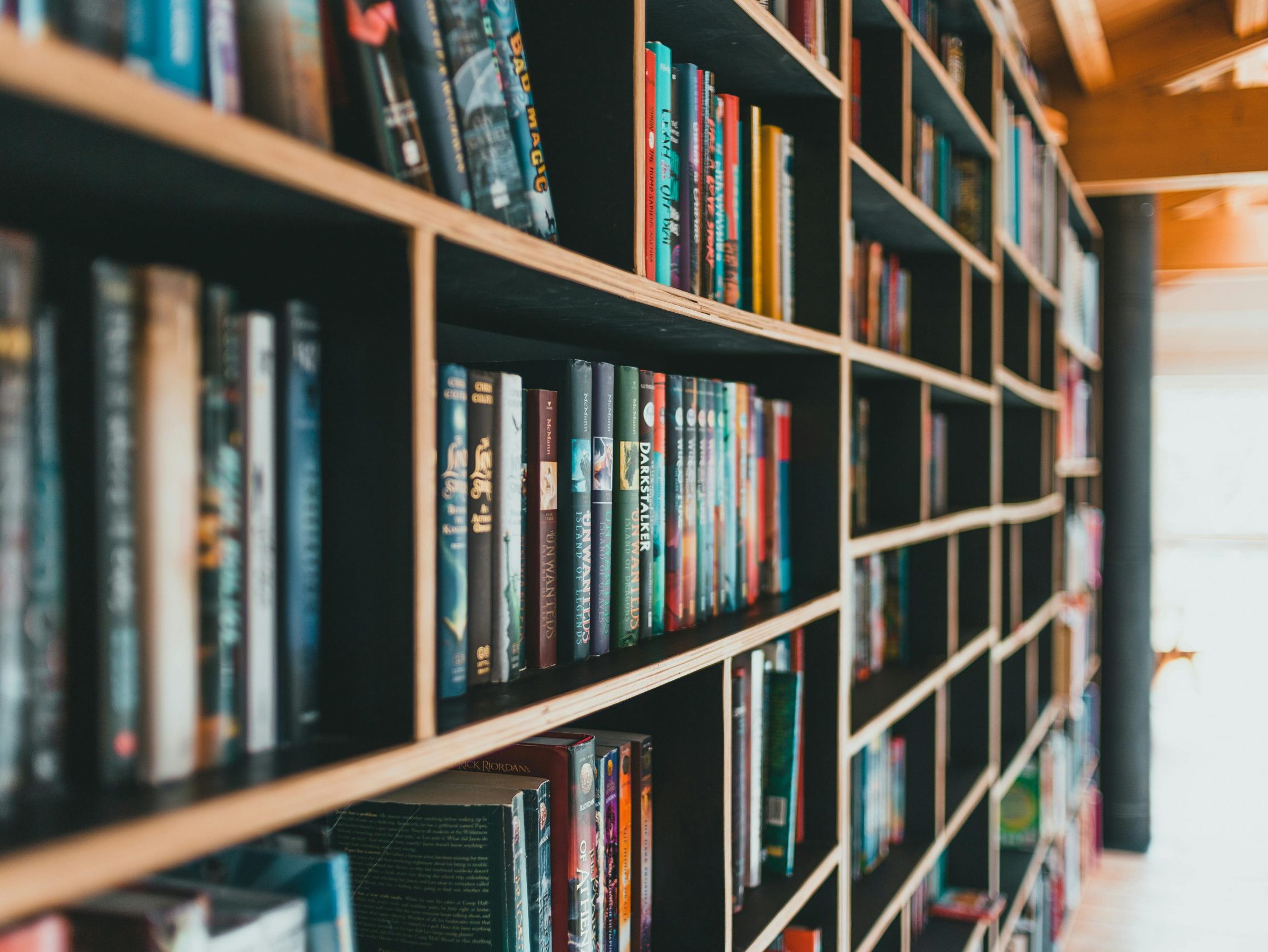 A perspective view of a bookshelf that is full of books.